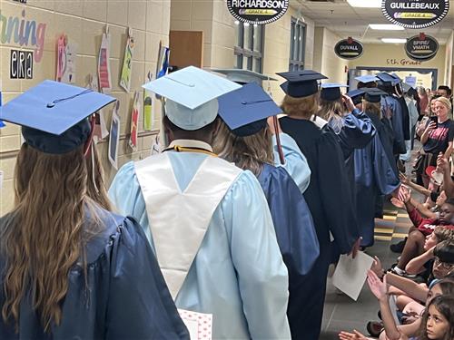 seniors in Bob Jones and James Clemens caps and gowns revisit Heritage Elementary where they attended elementary school